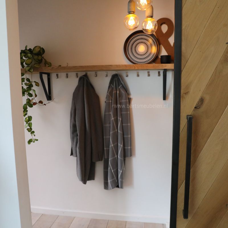 Schuifdeur binnen op maat van eikenhout met een stalen frame opent naar hal