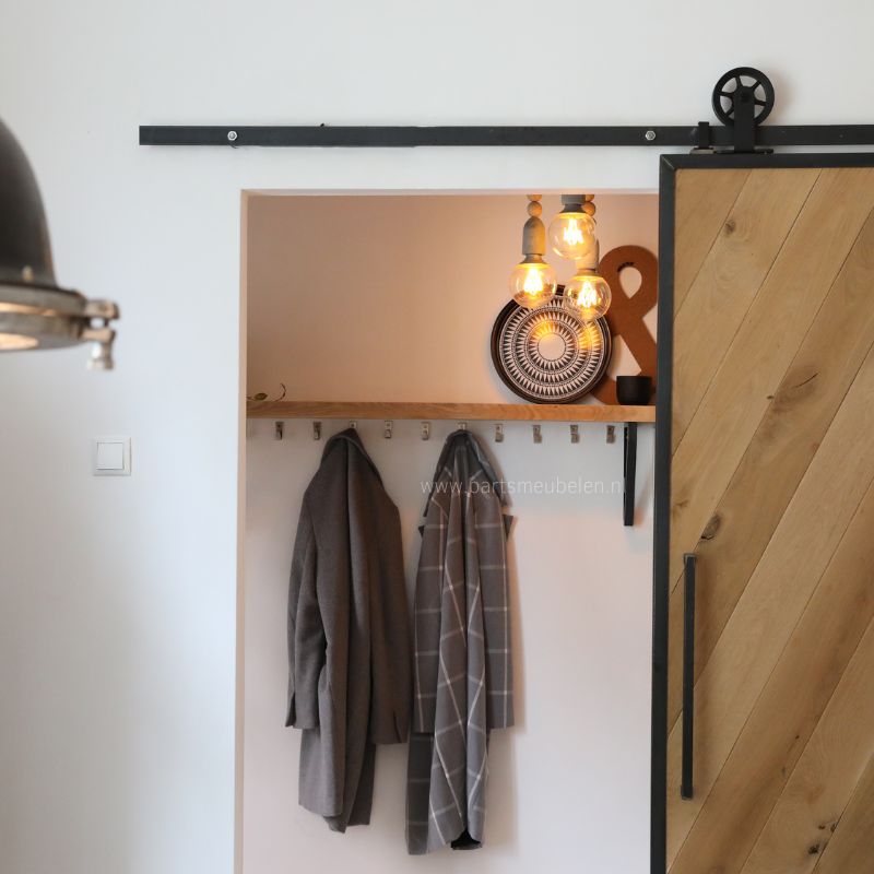 Schuifdeur binnen op maat van eikenhout met een stalen frame voor naar de hal