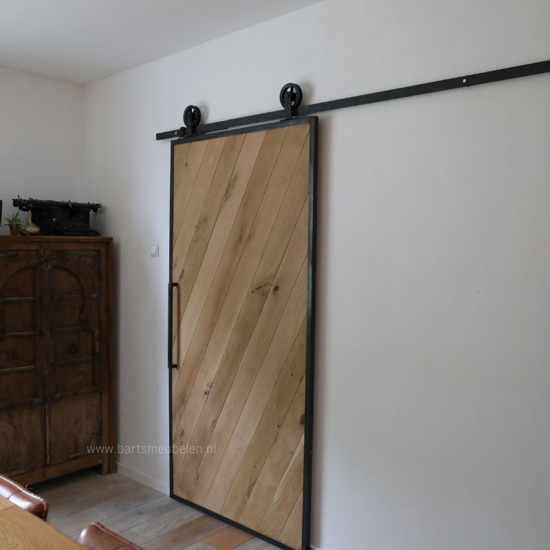 eikenhouten loftdeur in stalen frame op rails